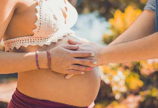 femme enceinte touchant son ventre, accompagner la grossesse de façon naturel