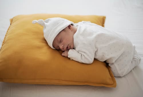 Bébé dormant paisiblement sur un coussin jaune