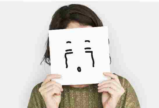 Femme qui se cache le visage derrière un masque triste-maladie auto-immune